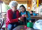 old women teaching lao girl how to weave on kajsiab womens workplace